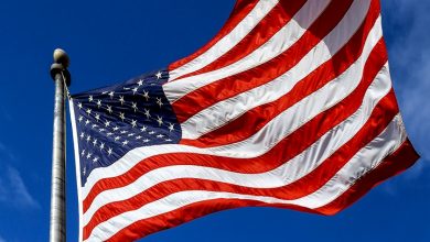 Low Angle View Of American Flag Waving Against Sky